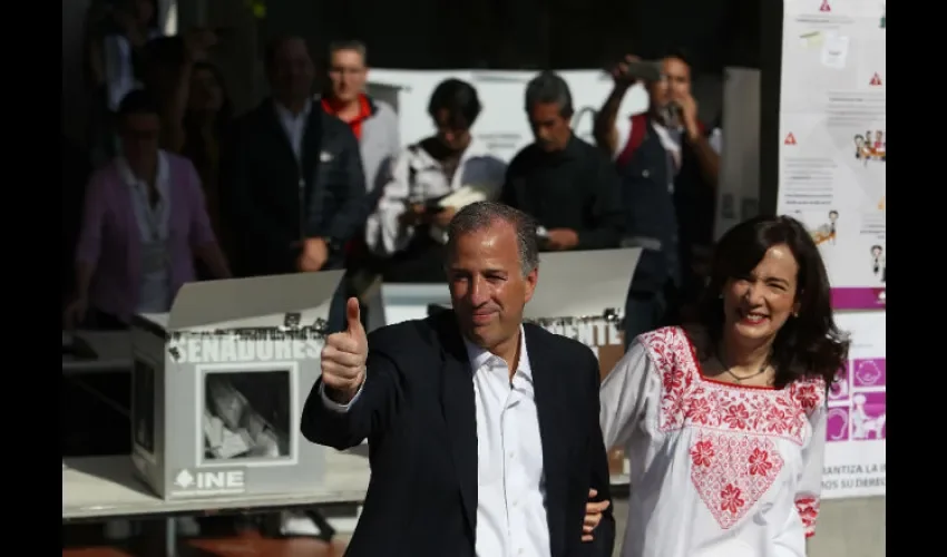 Antonio Meade y su esposa en la mesa de votación saludan a simpatizantes del PRI. FOTO/EFE