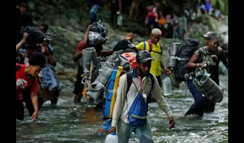 Fotografía del 28 de septiembre de 2021 que muestra a migrantes haitianos en su camino hacia Panamá por el Tapón del Darién en Acandi (Colombia). EFE